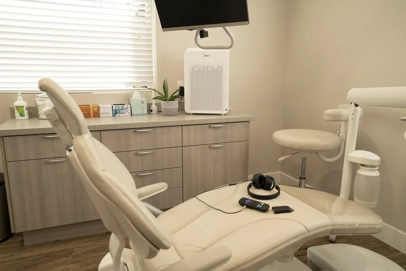 Dental chair with headphones and a TV remote set out for the patient