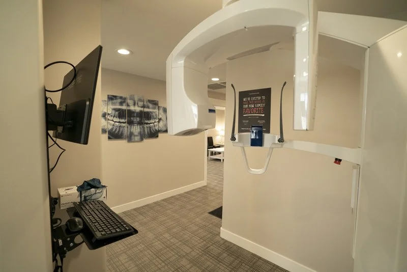 Panoramic X-ray unit beside framed dental X-ray wall art